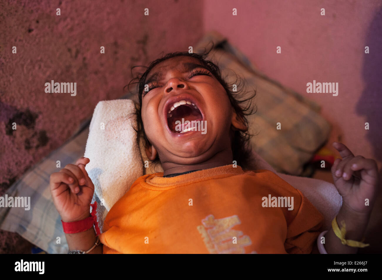 A crying young child baby at home in a slum in Mumbai, India. Stock Photo