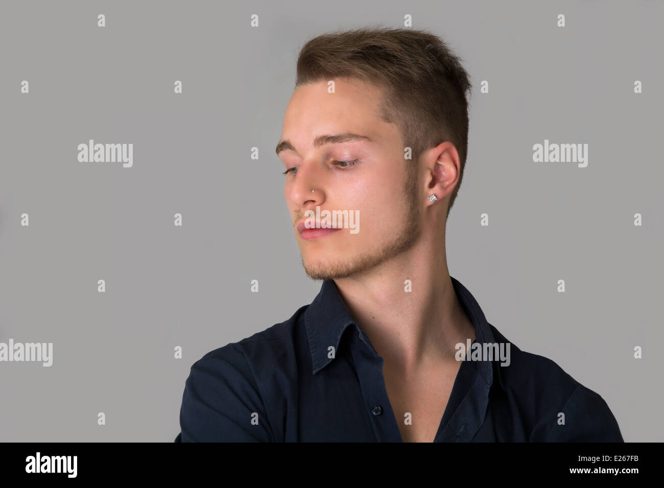 Profile view of sad young man looking down Stock Photo - Alamy