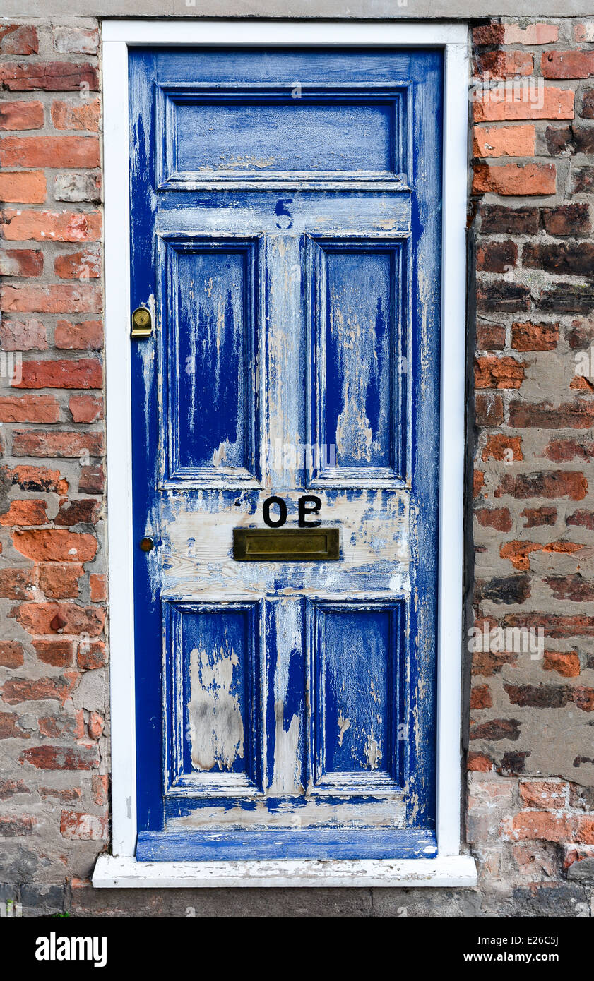 Worn blue and white door and a brick wall. Number 5 and 20B. Stock Photo