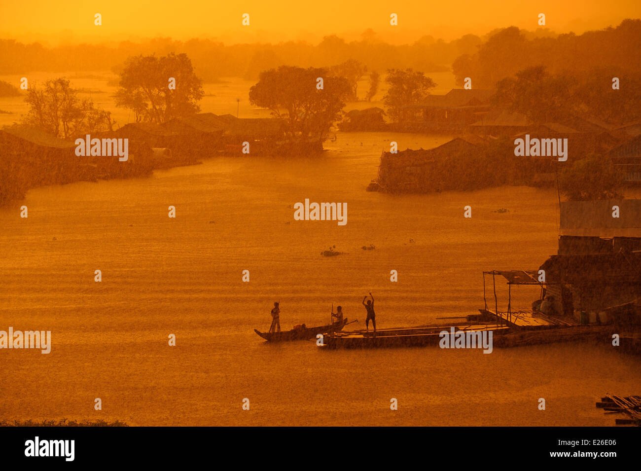 Monsoon rain at sunset over a floating village on the Tonle Sap Lake Stock Photo