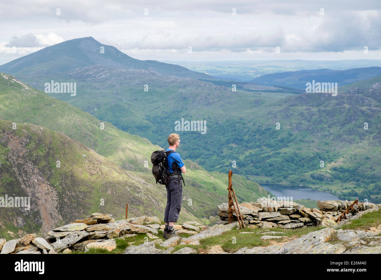 Hiker on Yr Aran looking at view to Nant Gwynant valley with Moel Siabod beyond in mountains of Snowdonia National Park (Eryri). Wales UK Britain Stock Photo