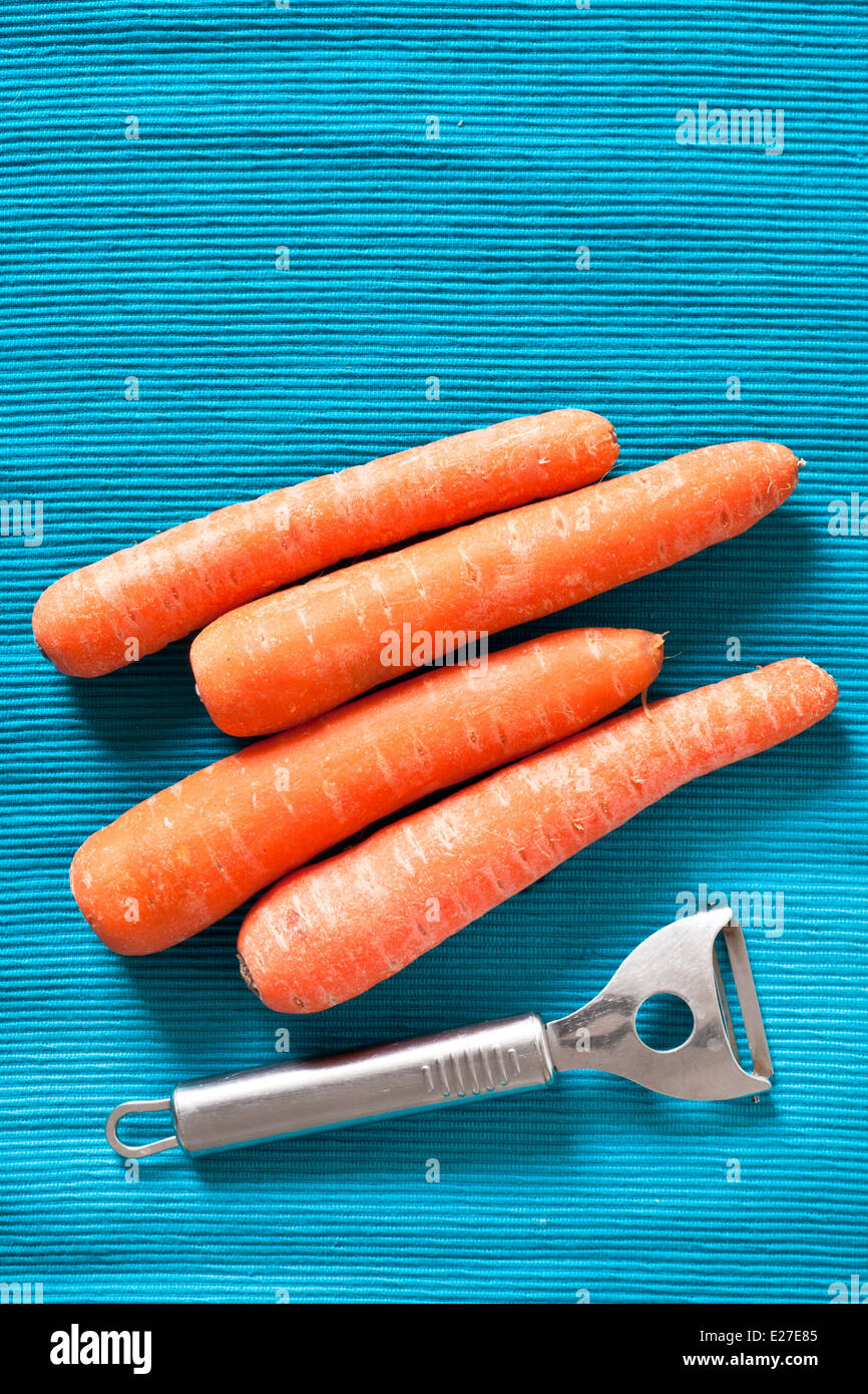 Raw carrots on a worktop with a peeler Stock Photo Alamy