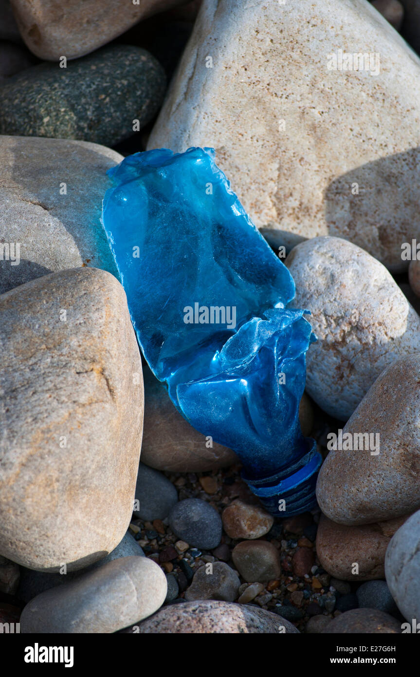 Blue plastic bottle on pebble beach Stock Photo