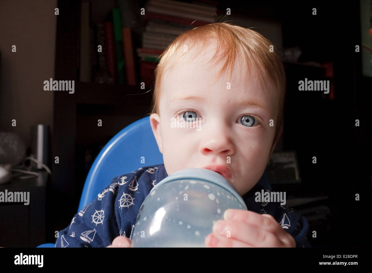 An 11-month old baby boy drinking milk from a bottle Stock Photo