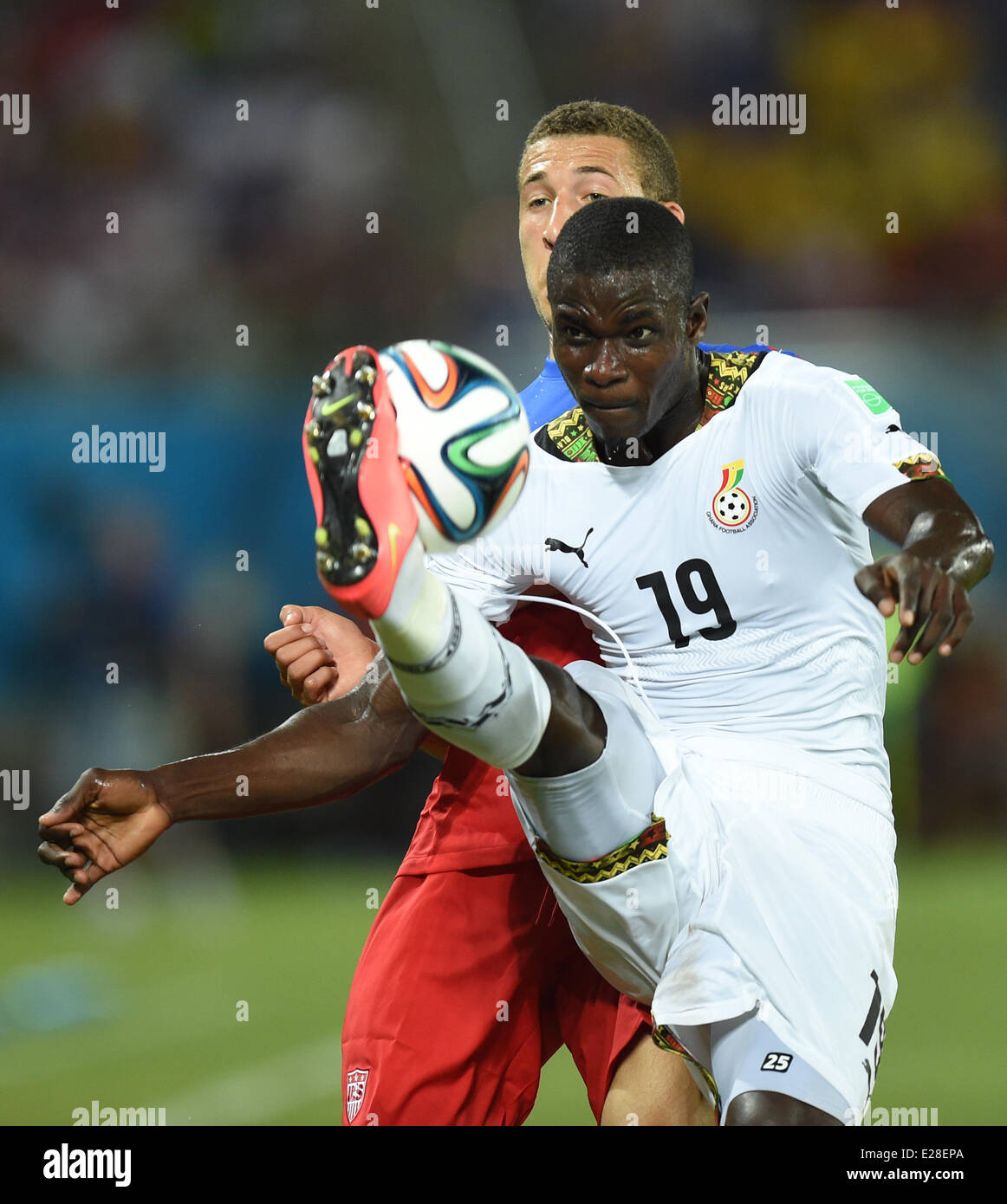 Natal, Brazil. 16th June, 2014. Fabian Johnson of USA in action against of Jonathan Mensah (R) Ghana during the FIFA World Cup 2014 group G preliminary round match between Ghana and the USA at the Estadio Arena das Dunas Stadium in Natal, Brazil, 16 June 2014. Credit:  dpa picture alliance/Alamy Live News Stock Photo
