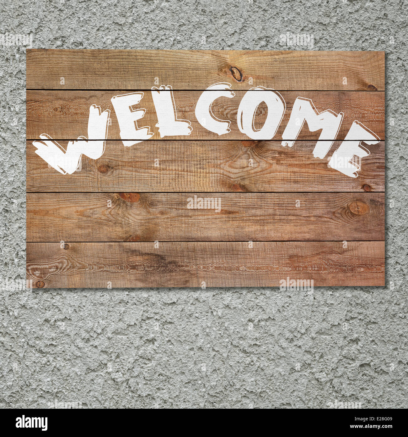Vintage “welcome” wooden sign on gray stucco concrete wall Stock Photo