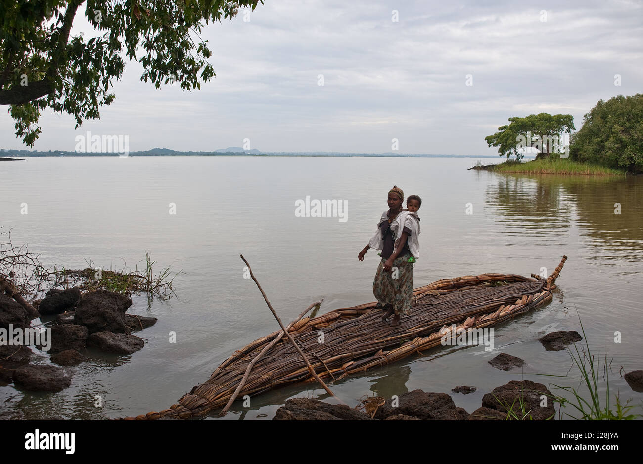 Mother ready to cross the Blue Nile river on a papyrus boat. In the background, the Lake Tana ( the source of the river). Stock Photo