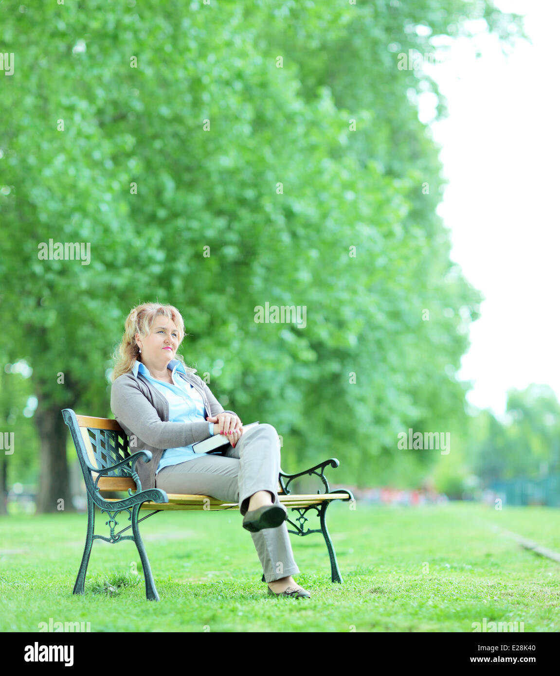 Mature woman sitting alone in the park Stock Photo