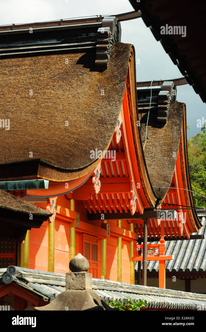 Curved roof line and bright orange painted walls of a Japanese Shinto shrine. Stock Photo