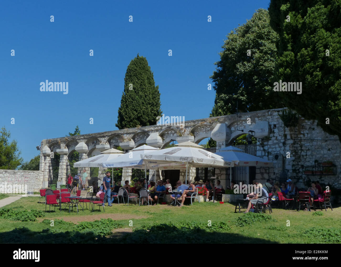 People sitting in an outdoor cafe on a hot sunny day under sunshades in Rovinj, Croatia Stock Photo