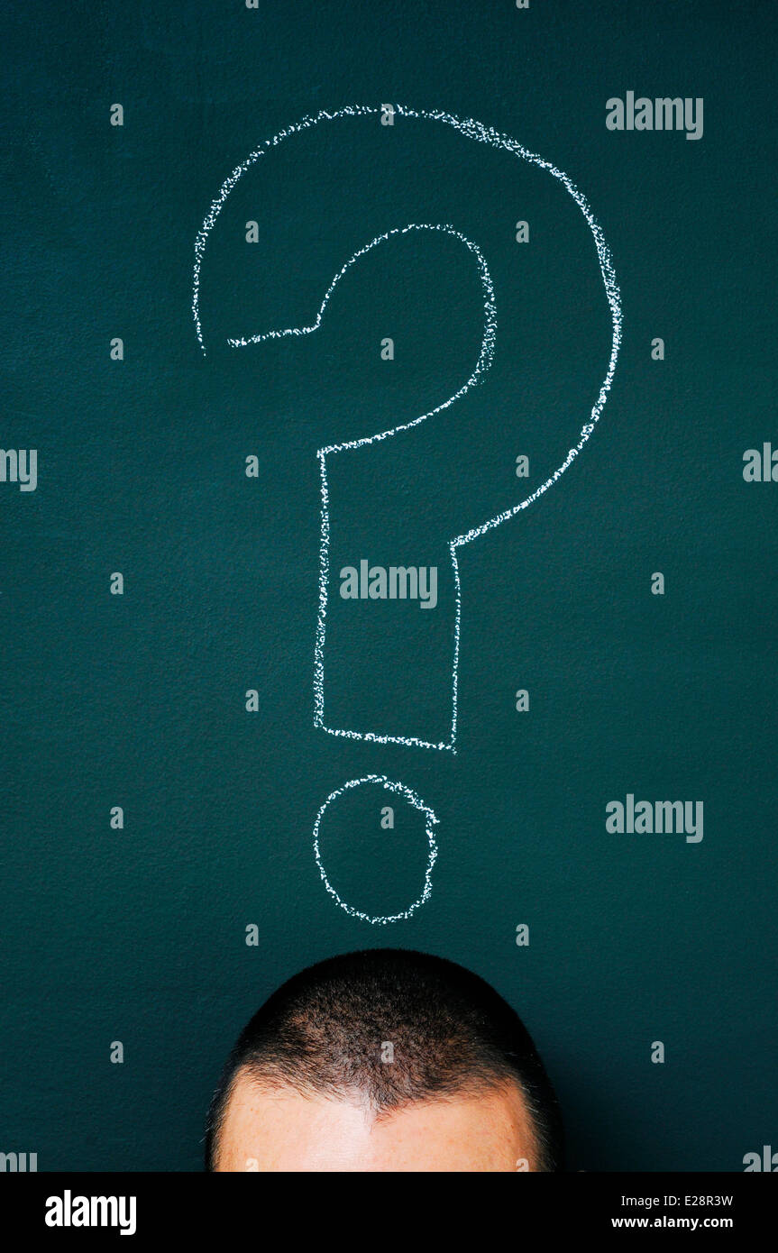 a man over a blackboard with a question mark drawn in it Stock Photo