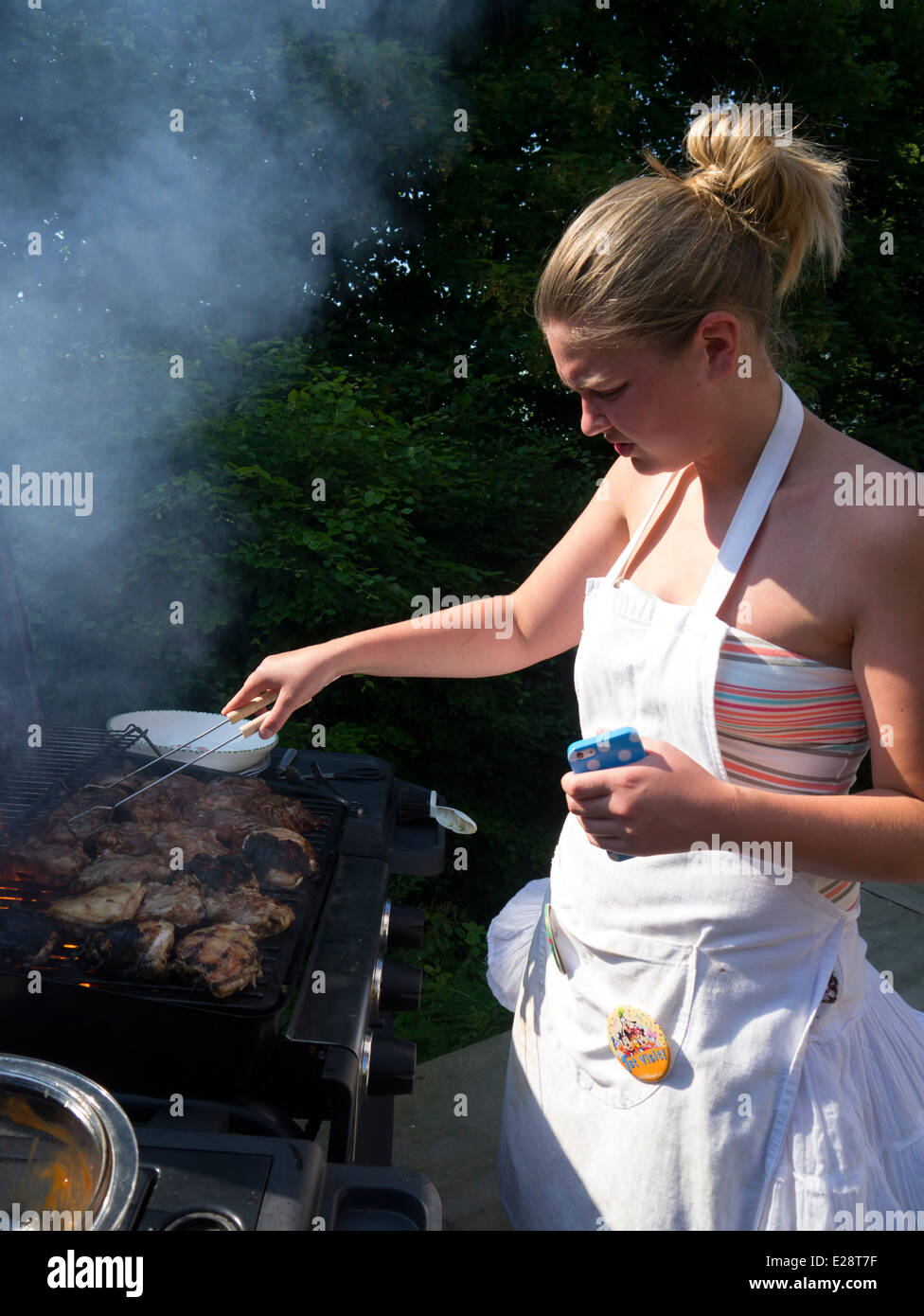 Woman cooking on a barbecue. Stock Photo