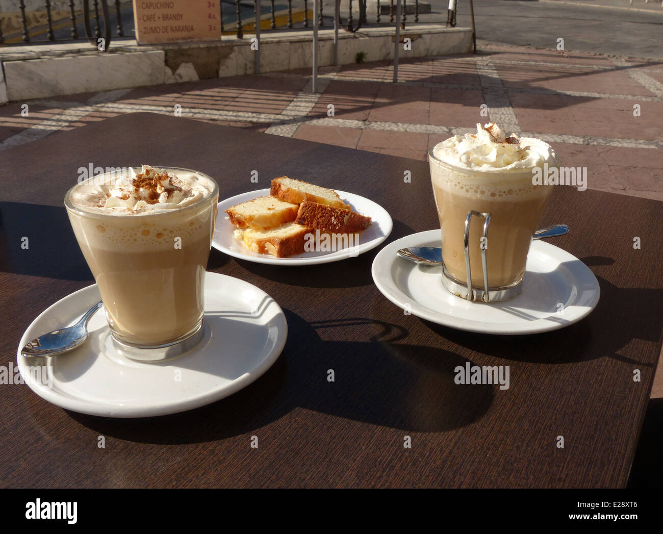 Two coffees on a cafe table in Ronda town square with cake Stock Photo