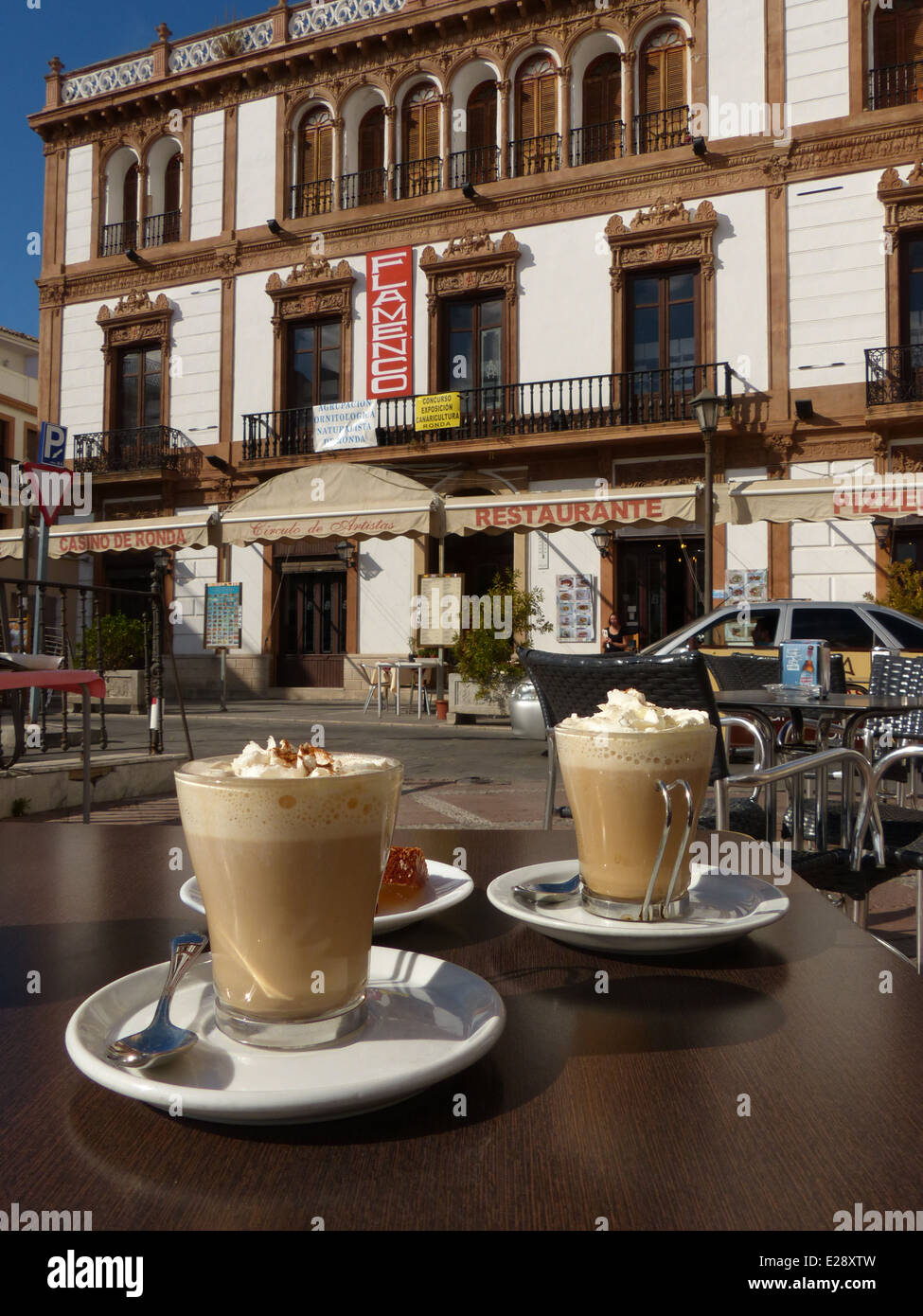 Two coffees on a cafe table in front of an ornate building in Ronda town square Stock Photo