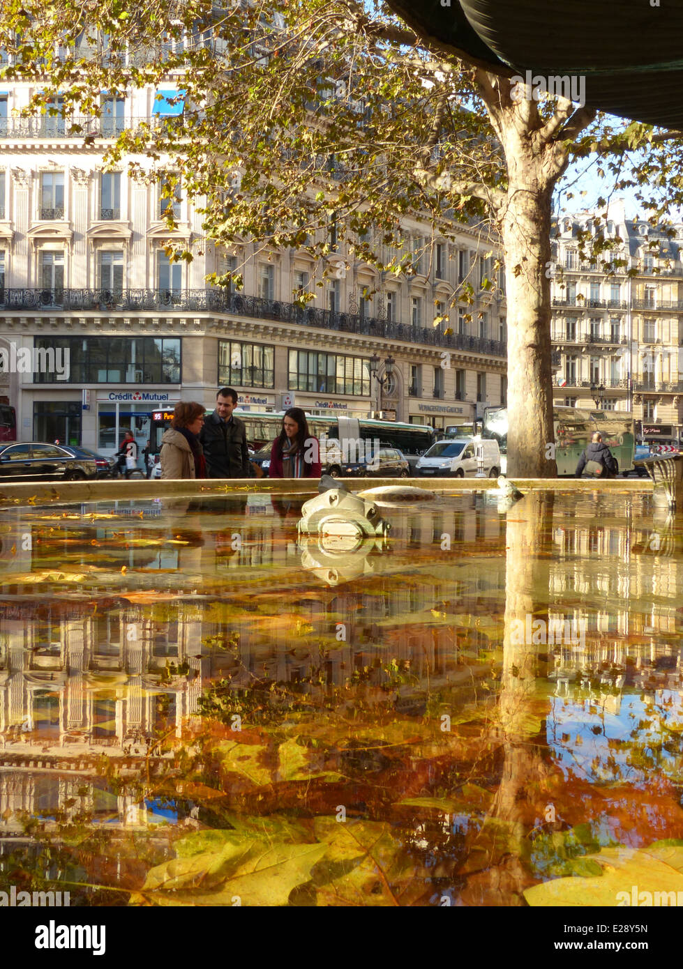 A Paris street scene with a pond in the foreground and people chatting Stock Photo