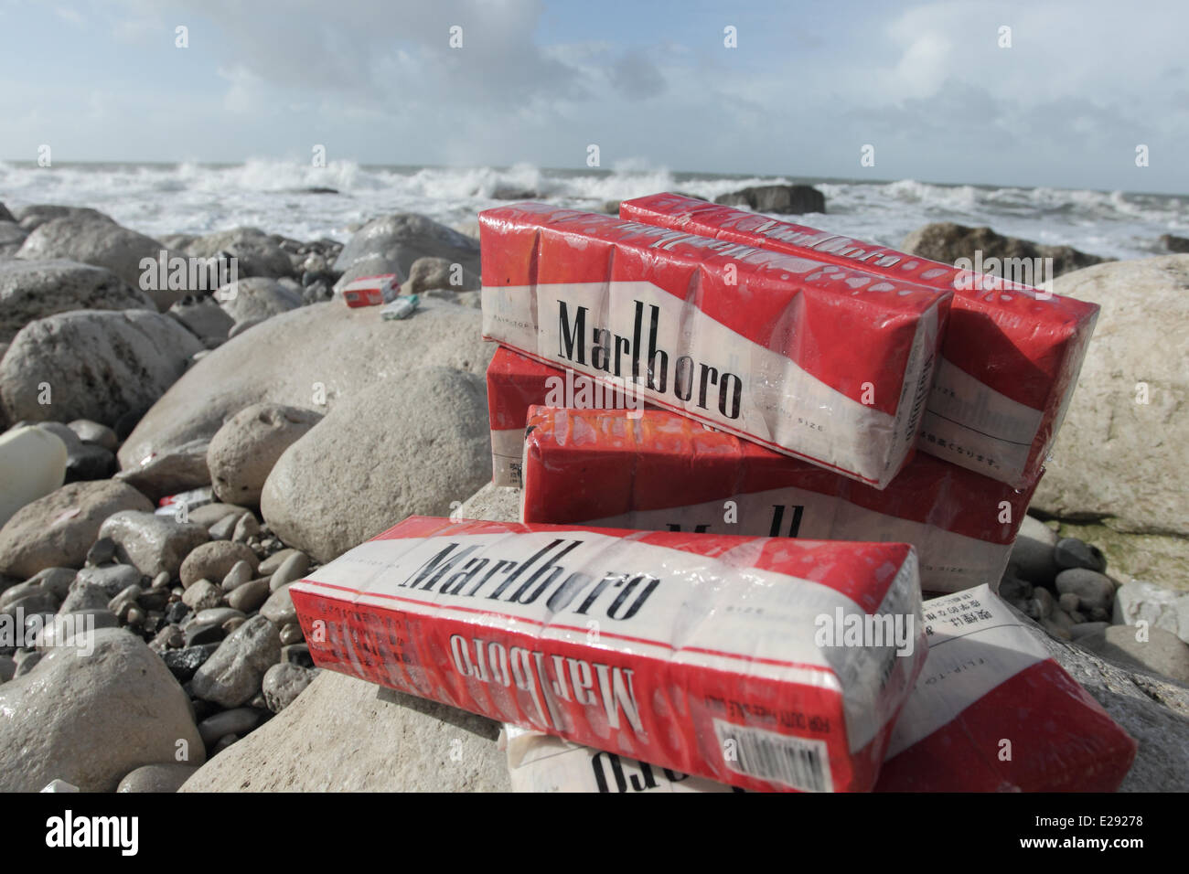Cigarettes washed up on beach after container spill, Isle of Portland, Dorset, England, February 2014 Stock Photo