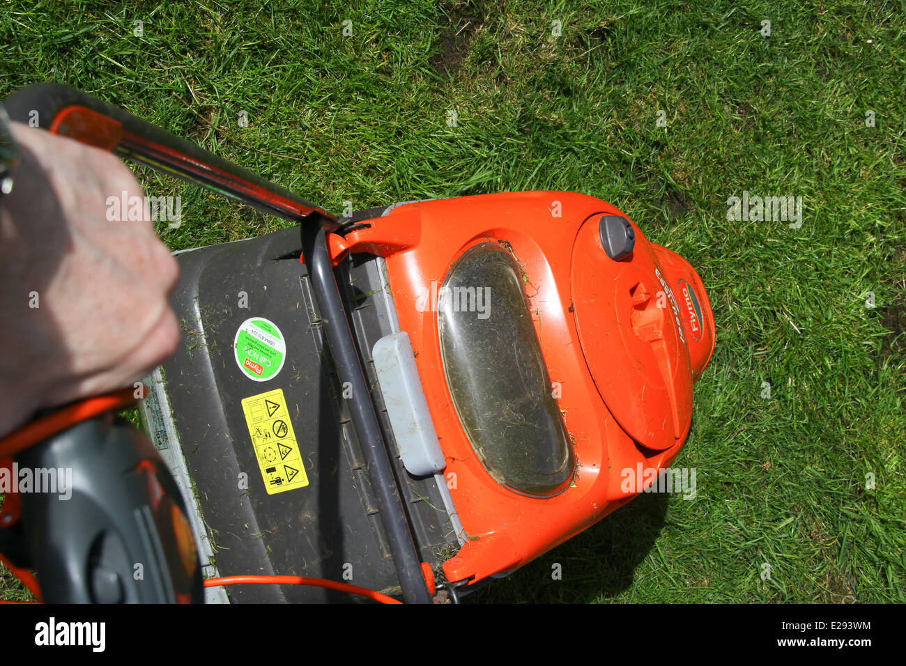 Mowing grass in garden with Flymo hover lawn mower Stock Photo