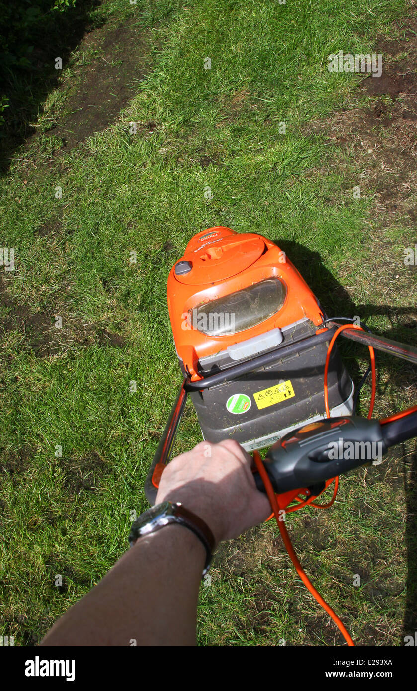 Mowing grass in garden with Flymo hover lawn mower Stock Photo