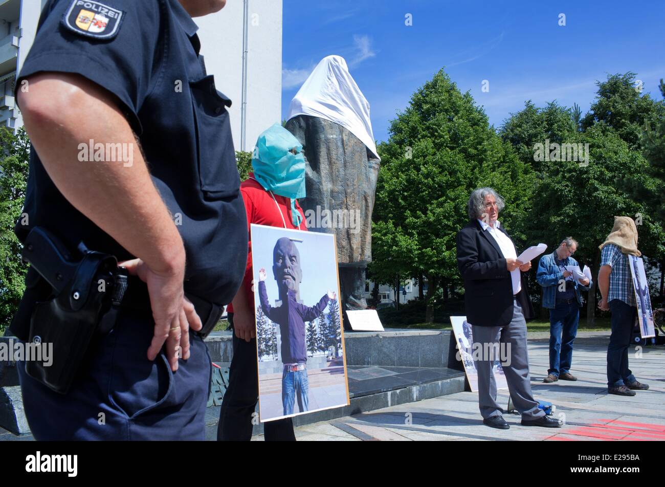 Schwerin, Germany. 17th June, 2014. The partially covered Lenin memorial is pictured behind former East German regime critic, Alexander Bauersfeld, in Schwerin, Germany, 17 June 2014. The action is meant to commemorate the workers' uprising on 17 June 1953 and the victims of the communist dictatorship in East Germany. 66 year old Bauersfeld is demanding that the bronze statue be taken down in the Grosser Dreesch neighborhood. Photo: JENS BUETTNER/dpa/Alamy Live News Stock Photo