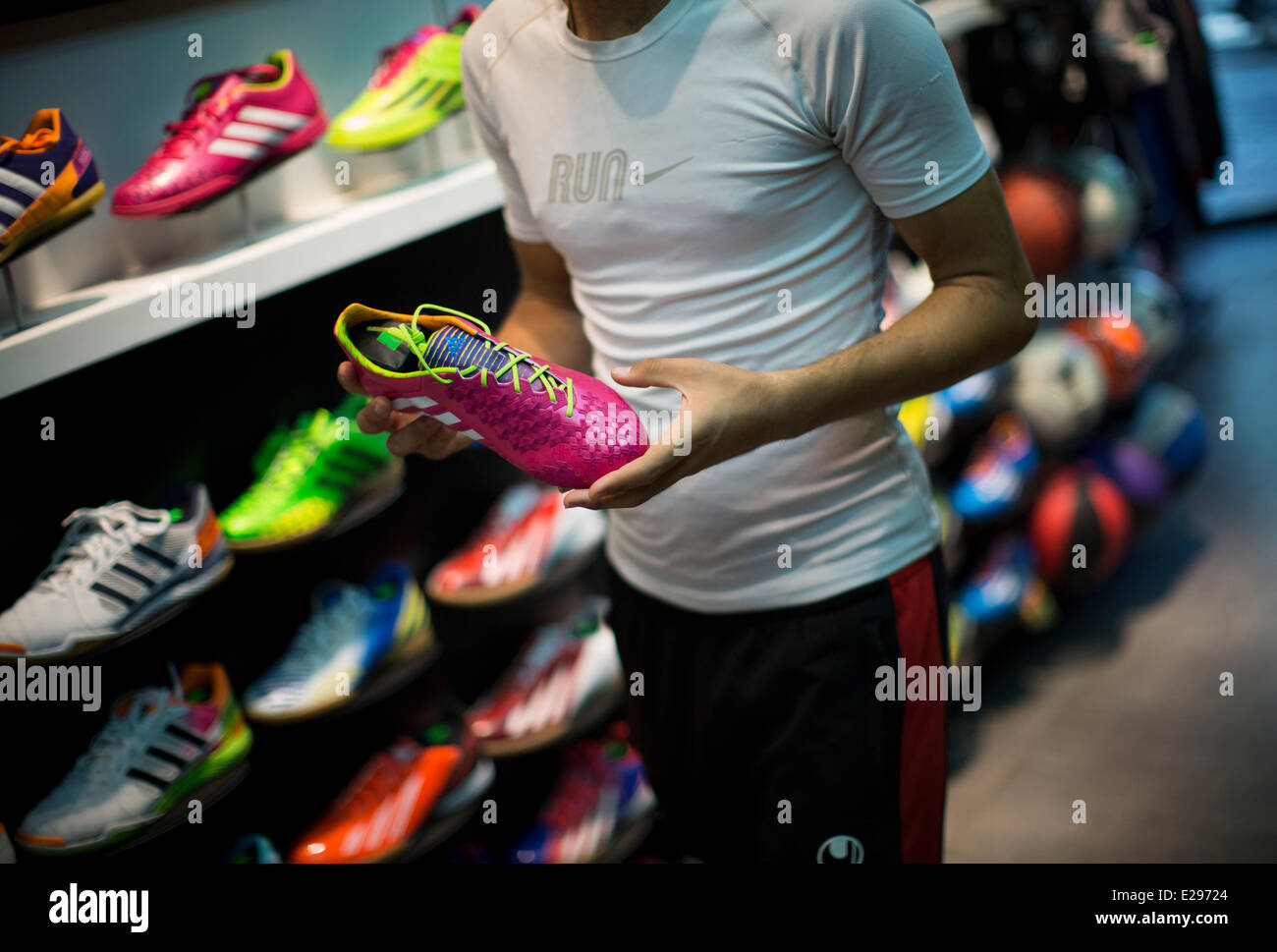 Tehran, Iran. 16th June, 2014. An Iranian customer holds an original FIFA  2014 World Cup shoe while shopping at adidas sport wear shop in central  Tehran. Credit: Morteza Nikoubazl/ZUMA Press/Alamy Live News