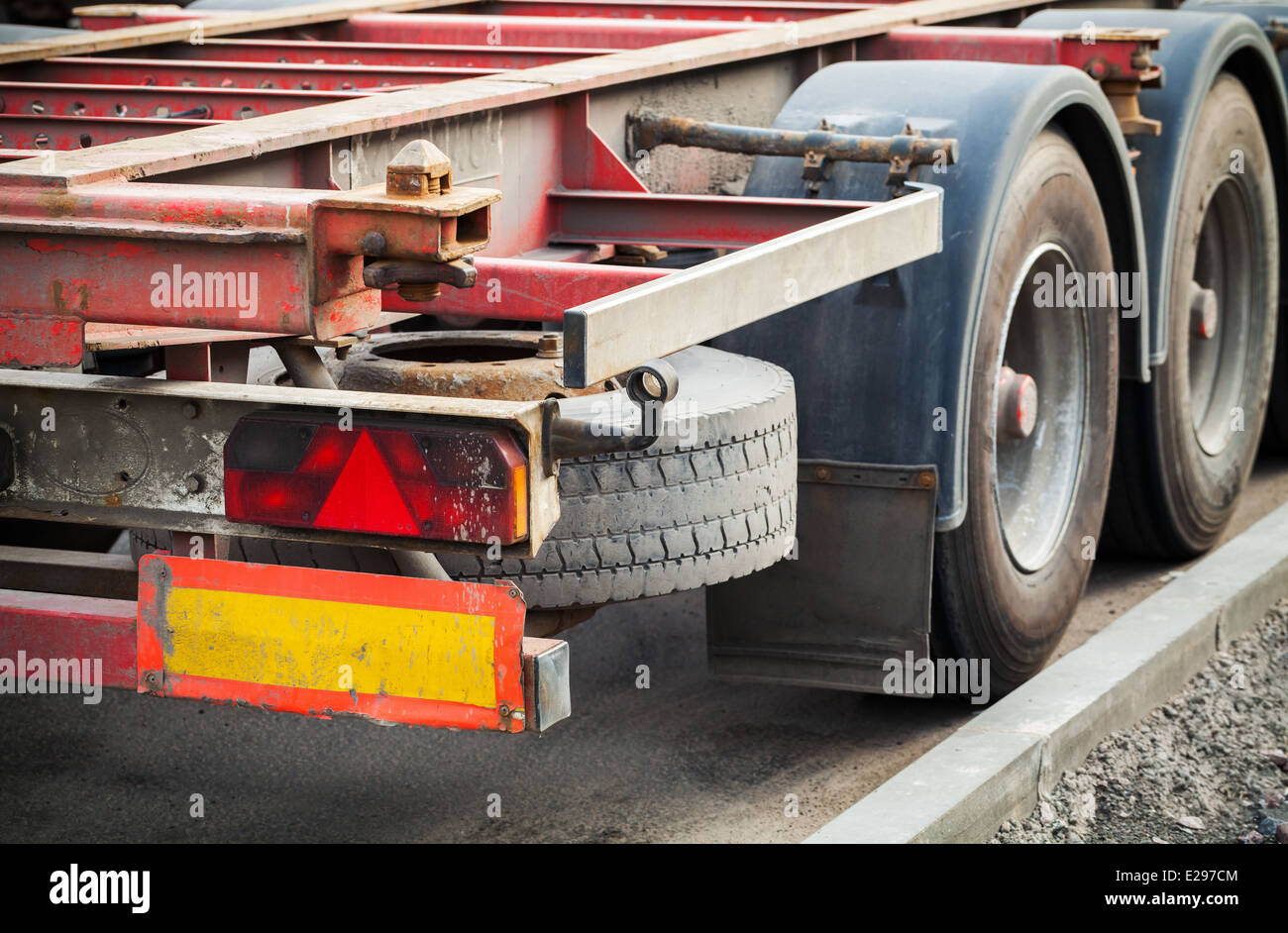 Back part with taillight of empty truck cargo trailer on asphalt road Stock Photo