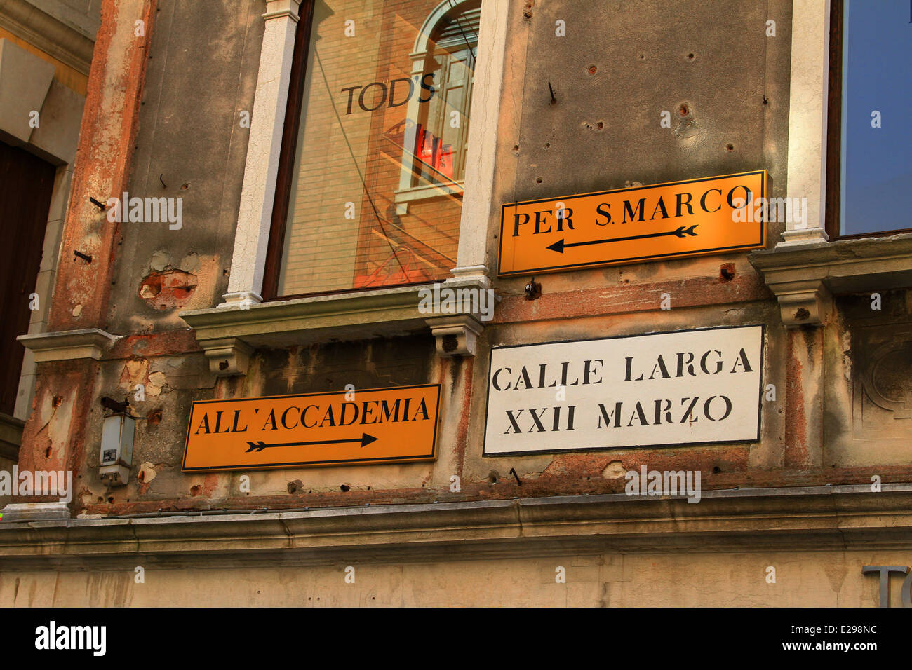 Venice, Tod's,Per S.Marco, All'accademia, Calle Larga XXII Marzo. Orange signs directional walking around the back allays Venice Stock Photo