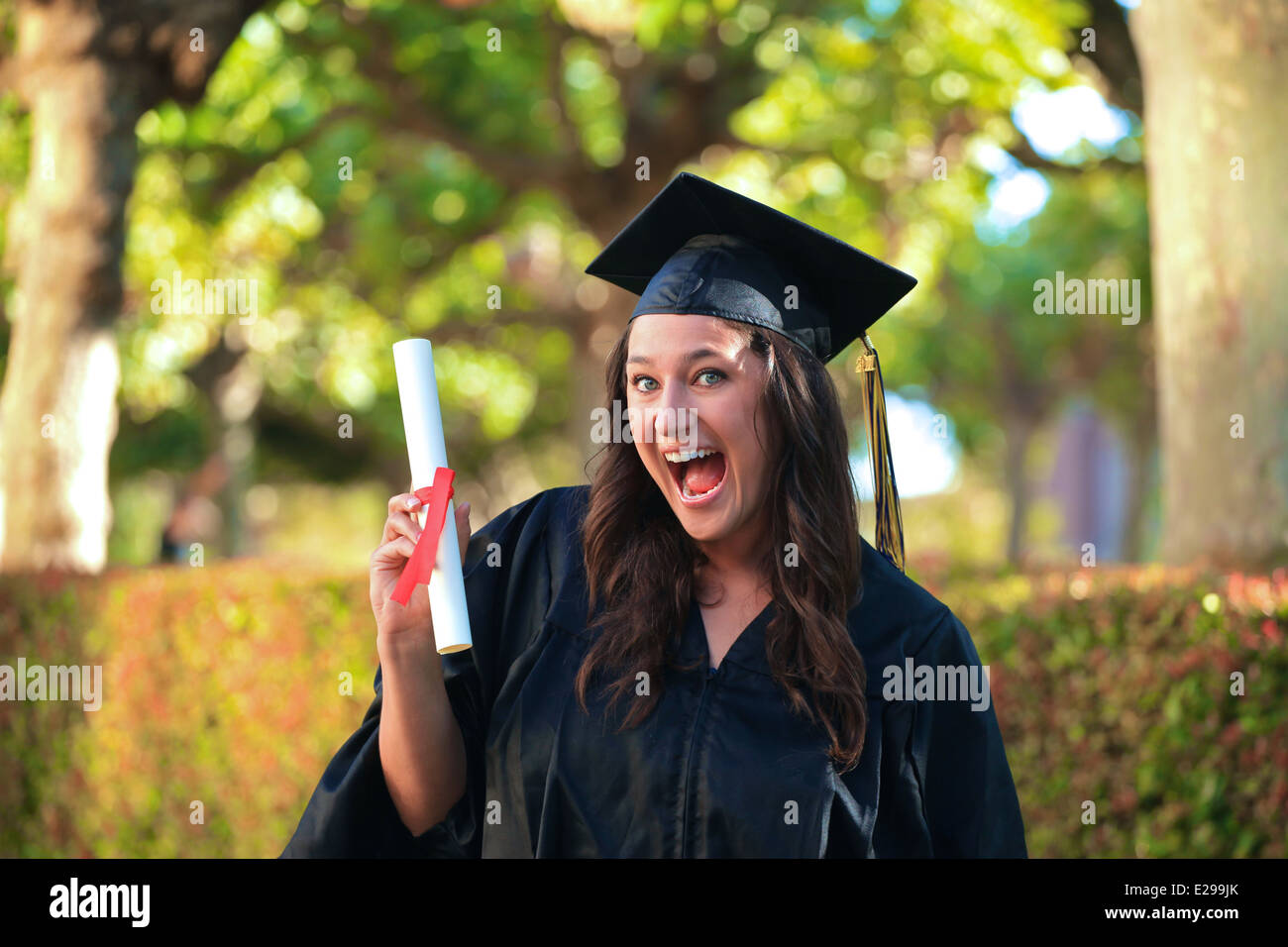 A beautiful girl with brown hair and blue eyes wearing a college graduation cap and gown smiles and holds her diploma Stock Photo - Alamy A beautiful girl with brown hair and blue eyes wearing a college graduation cap and gown smiles and holds her diploma Stock Photo - Alamy