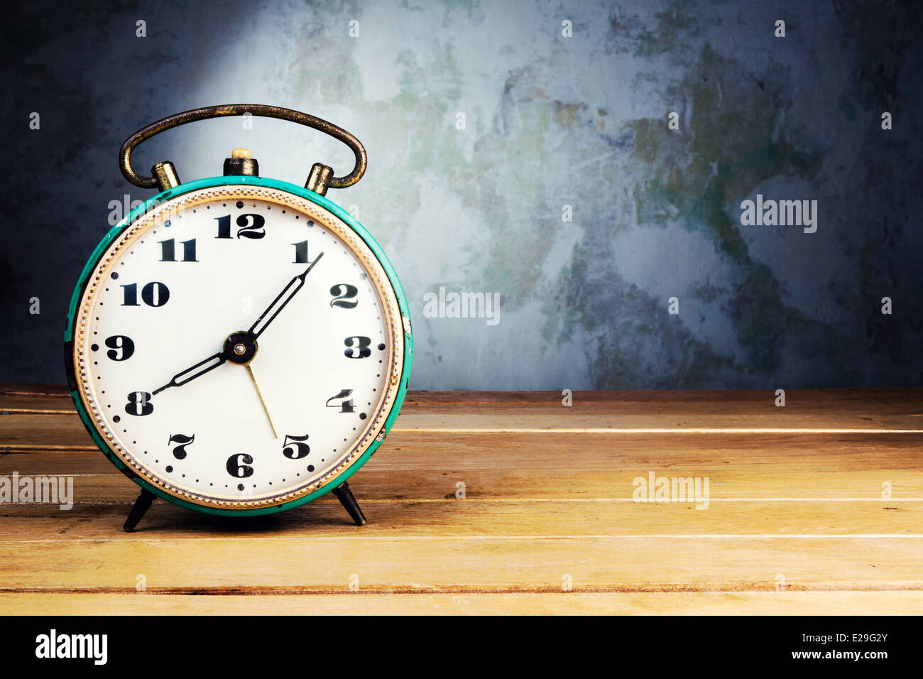 Retro alarm clock on wooden table on grunge background Stock Photo - Alamy
