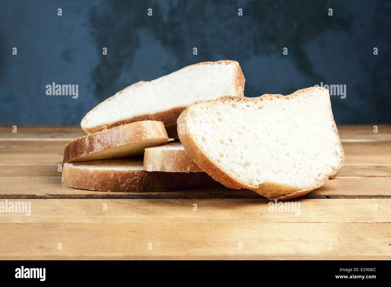Slices of bread on old wooden table Stock Photo - Alamy