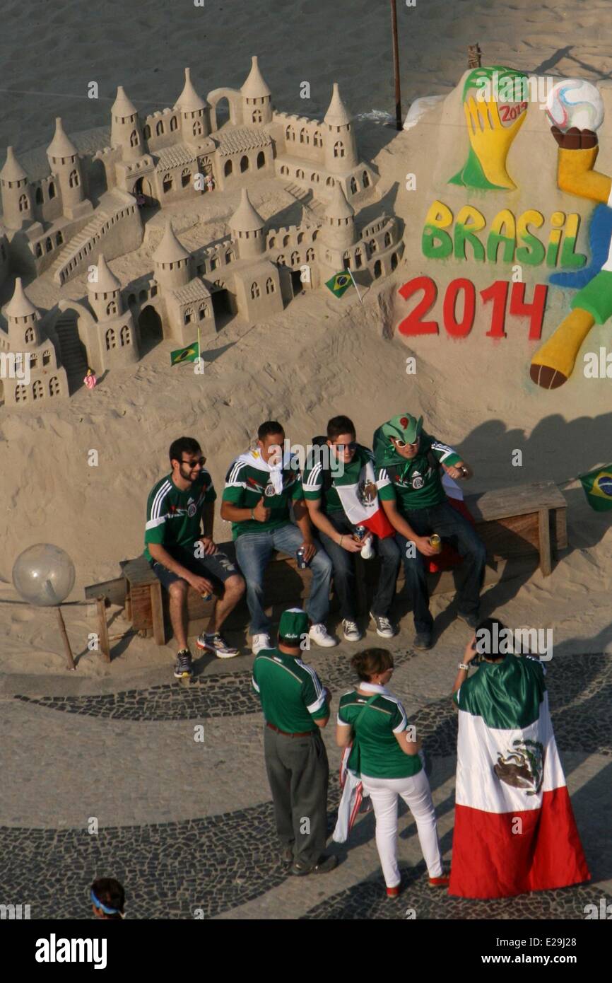 Rio de Janeiro, Brazil, 17th June, 2014.  Mexican fans take photos in front of a sand sculpture at Copacabana Beach, before the match against Brazil. Credit:  Maria Adelaide Silva/Alamy Live News Stock Photo