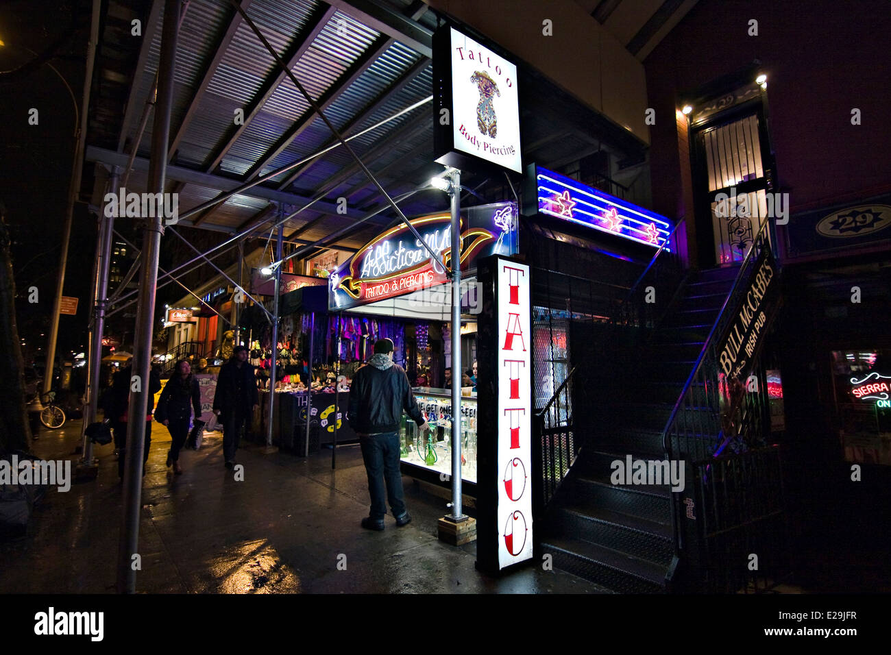 Addiction NYC Tattoo Shop & Bull McCabes Irish Pub at night in New York's Lower East Side Neighborhood of Greenwich Village Stock Photo