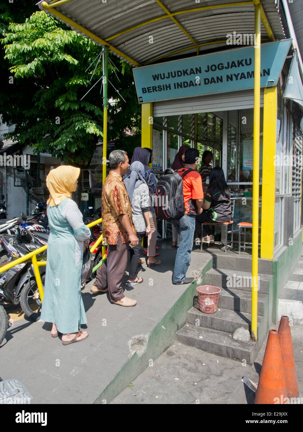Passengers queue at bus  stop  in Yogyakarta Indonesia  