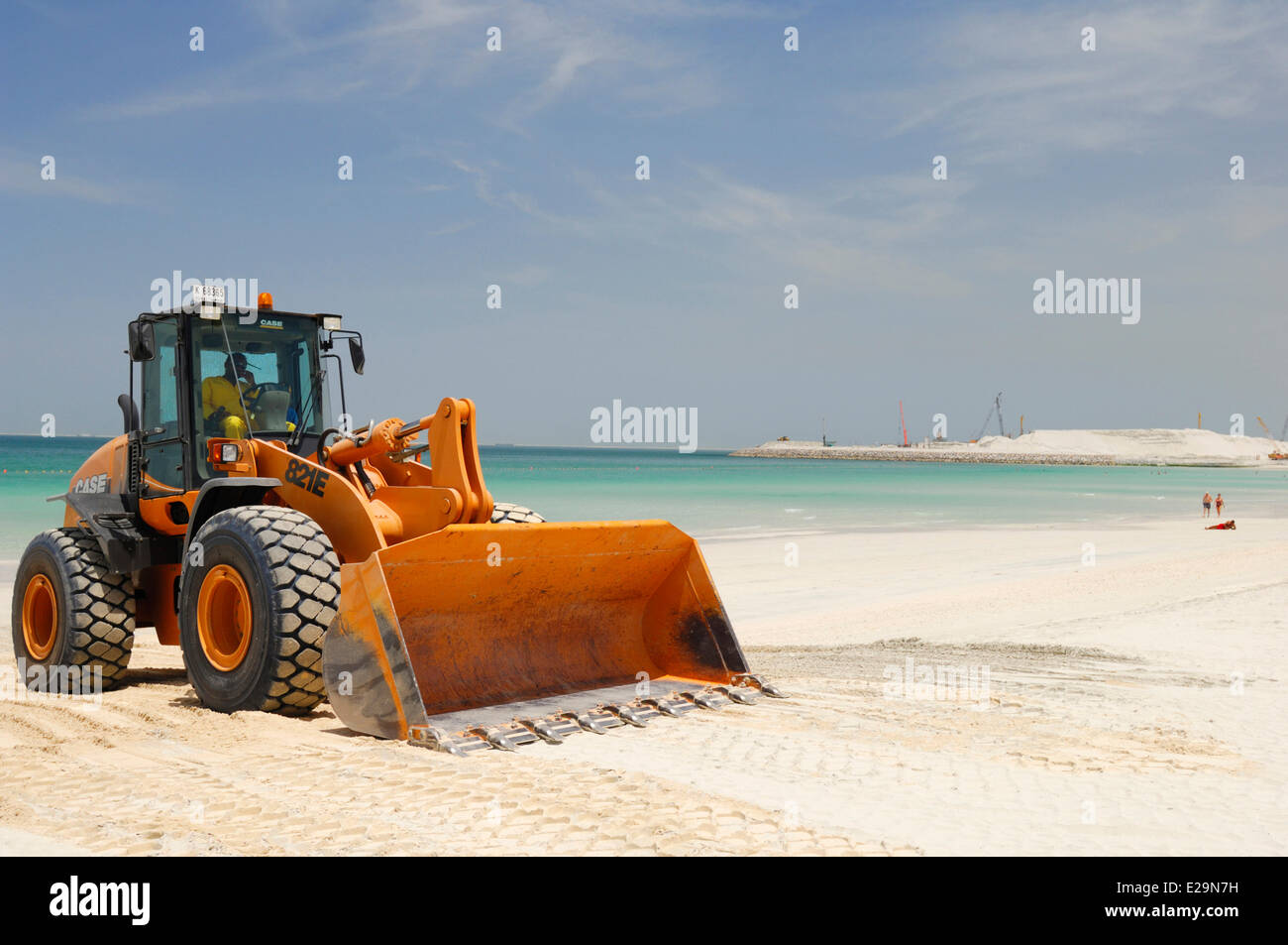 United Arab Emirates, Dubai emirate, Jumeirah, Backhoe on Jumeirah beach with in the background the site of the Dubai City Stock Photo
