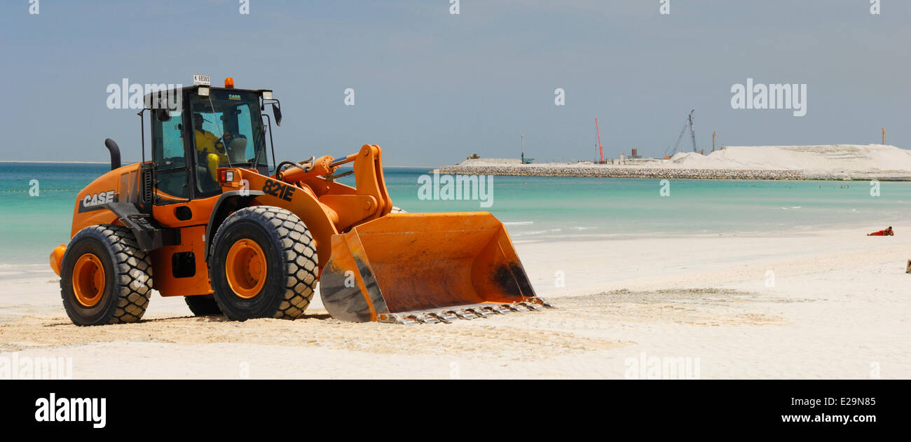 United Arab Emirates, Dubai emirate, Jumeirah, Backhoe on Jumeirah beach with in the background the site of the Dubai City Stock Photo