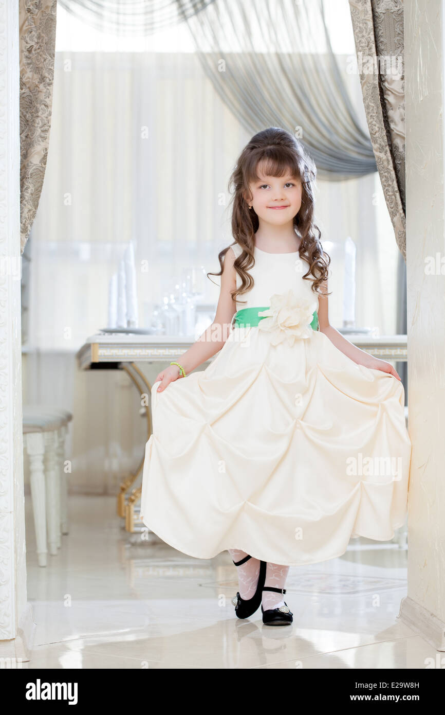 Lovely little girl posing in white elegant dress Stock Photo - Alamy
