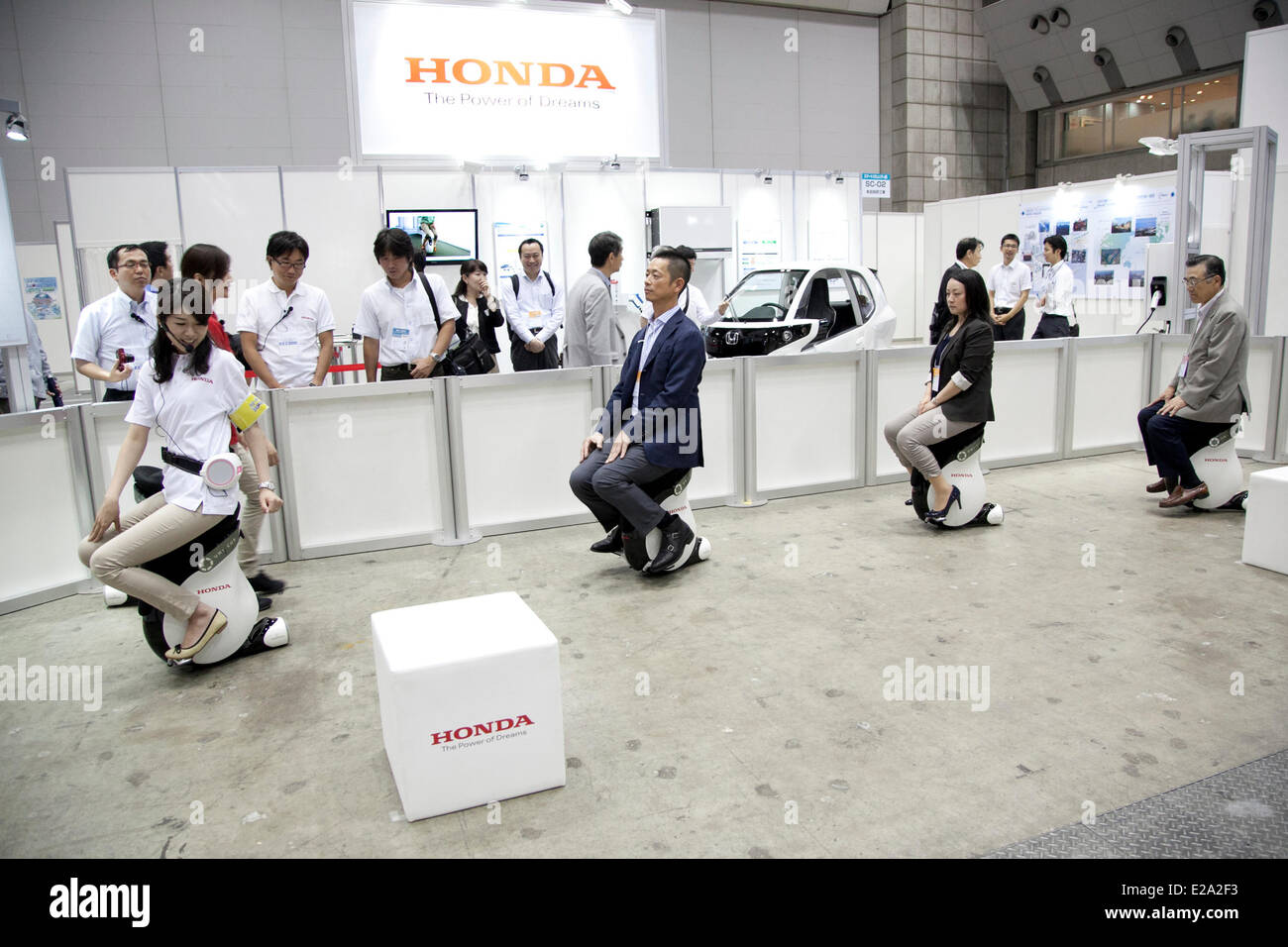 Tokyo, Japan. 18th June, 2014. An exhibitor and visitors drive a personal mobility device 'UNI-CUB' at the Smart Community Japan 2014 in Tokyo Big Sight on June 18, 2014. The exhibition brings the latests products and technologies divided in 5 categories, 'Smart Community Exhibition', 'Biomass Expo', 'Next Generation Vehicle Exhibition, and newly-created 'Community Cloud 2014', which introduces technology for urban development. This year 229 enterprises and organizations shows their products from June 18th to 20th. Credit:  Aflo Co. Ltd./Alamy Live News Stock Photo