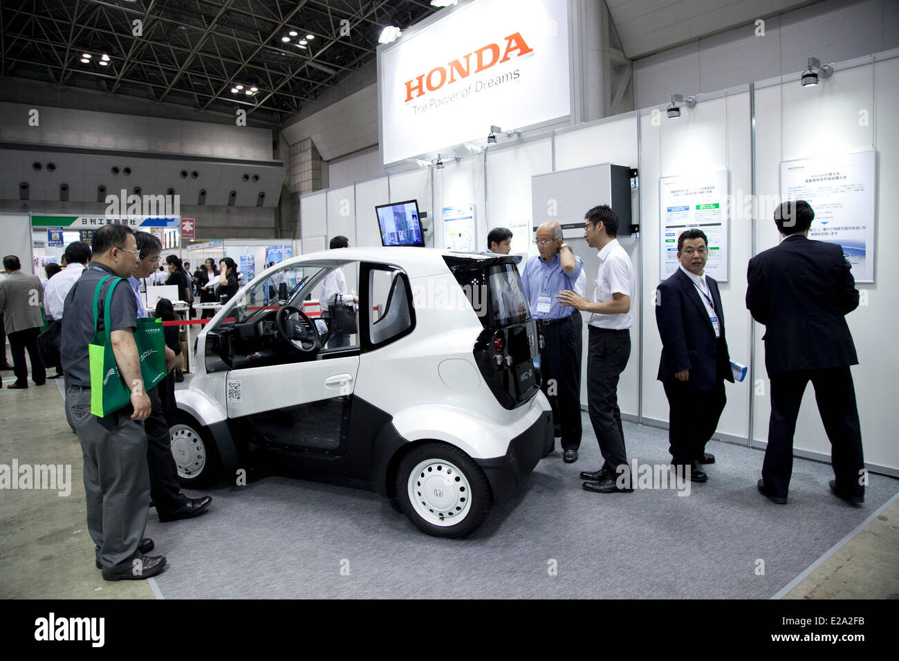 Tokyo, Japan. 18th June, 2014. – Visitors see the electric vehicle of Honda 'MC-B' at the Smart Community Japan 2014 in Tokyo Big Sight on June 18, 2014. The exhibition brings the latests products and technologies divided in 5 categories, 'Smart Community Exhibition', 'Biomass Expo', 'Next Generation Vehicle Exhibition, and newly-created 'Community Cloud 2014', which introduces technology for urban development. This year 229 enterprises and organizations shows their products from June 18th to 20th. Credit:  Aflo Co. Ltd./Alamy Live News Stock Photo