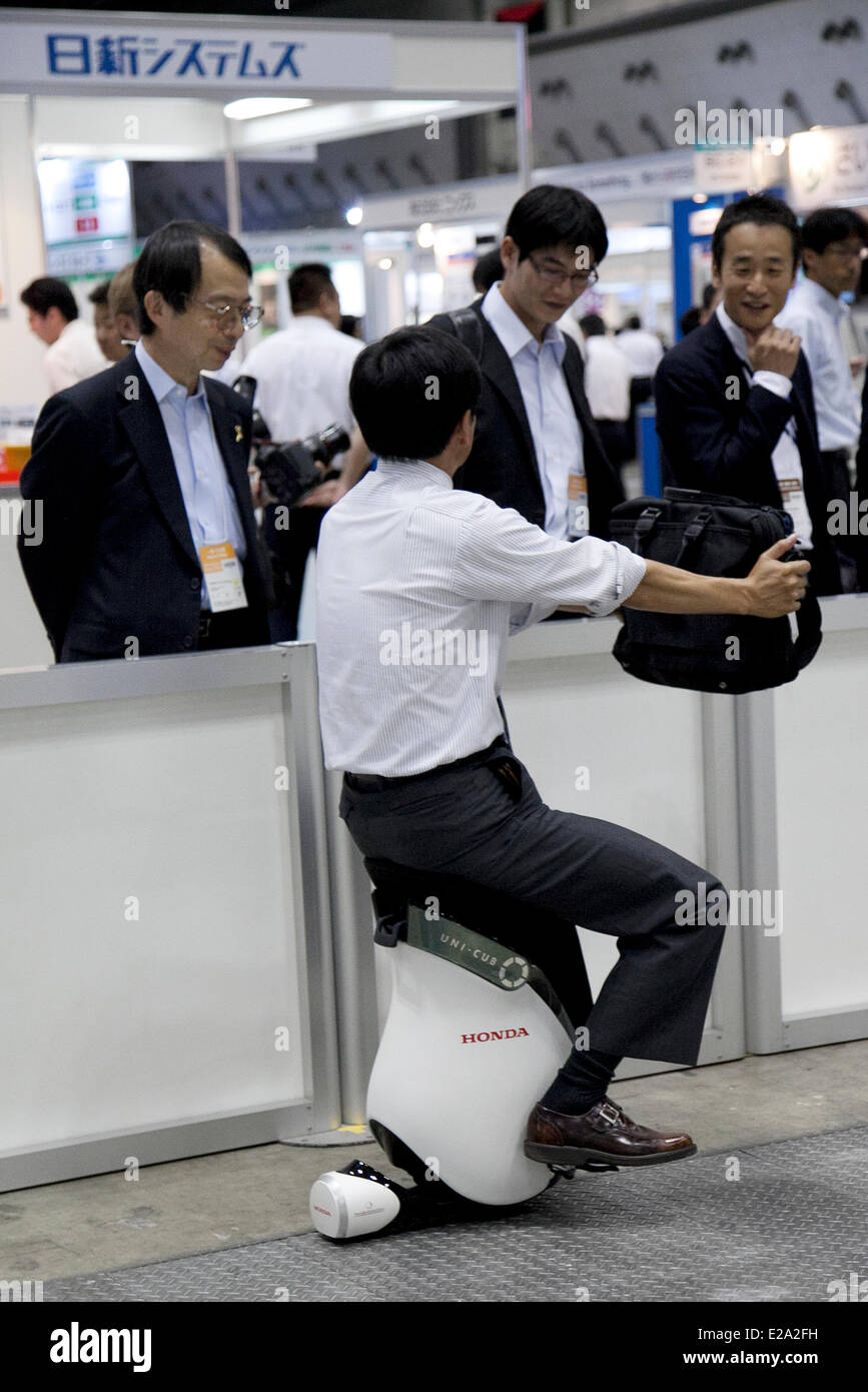 Tokyo, Japan. 18th June, 2014. An exhibitor drives a personal mobility device 'UNI-CUB' at the Smart Community Japan 2014 in Tokyo Big Sight on June 18, 2014. The exhibition brings the latests products and technologies divided in 5 categories, 'Smart Community Exhibition', 'Biomass Expo', 'Next Generation Vehicle Exhibition, and newly-created 'Community Cloud 2014', which introduces technology for urban development. This year 229 enterprises and organizations shows their products from June 18th to 20th. Credit:  Aflo Co. Ltd./Alamy Live News Stock Photo
