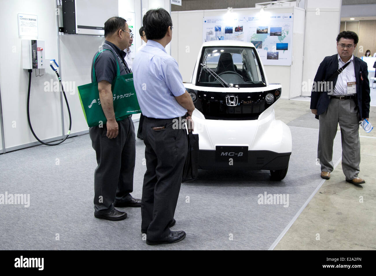 Tokyo, Japan. 18th June, 2014. – Visitors see the electric vehicle of Honda 'MC-B' at the Smart Community Japan 2014 in Tokyo Big Sight on June 18, 2014. The exhibition brings the latests products and technologies divided in 5 categories, 'Smart Community Exhibition', 'Biomass Expo', 'Next Generation Vehicle Exhibition, and newly-created 'Community Cloud 2014', which introduces technology for urban development. This year 229 enterprises and organizations shows their products from June 18th to 20th. Credit:  Aflo Co. Ltd./Alamy Live News Stock Photo