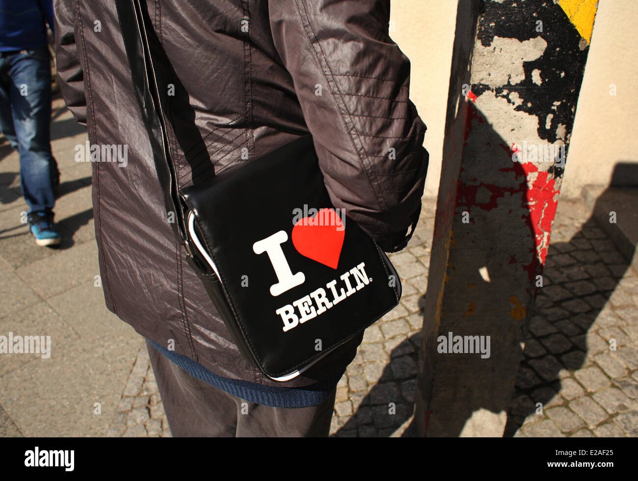 A tourist is carryin a bag with the red heart and the 'I love Berlin' near  Checkpoint Charlie in Berlin,  April 13, 2014. The photo is part of a series on tourism in Berlin. Photo: Wolfram Steinberg dpa Stock Photo