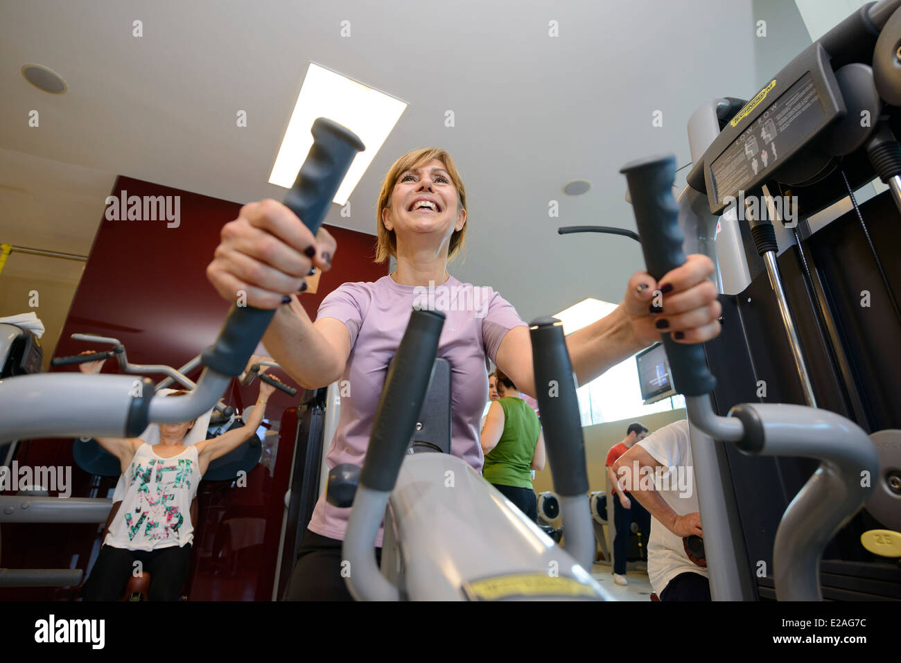 Middle aged woman working out on a rowing machine at the gym Stock Photo