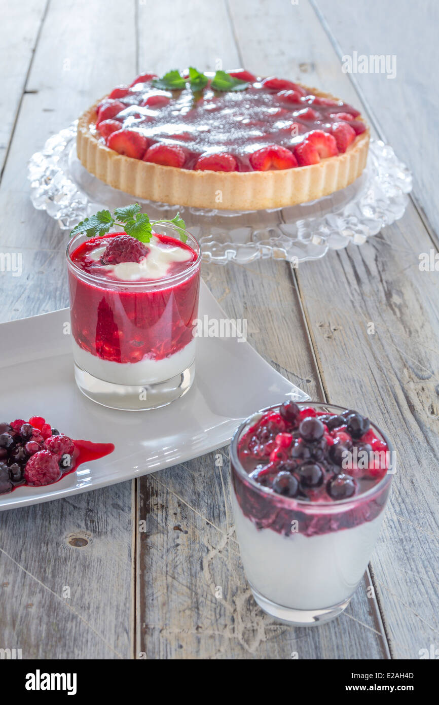Collection of summer desserts with mixed berries yoghurt, raspberry cream and strawberry cake Stock Photo