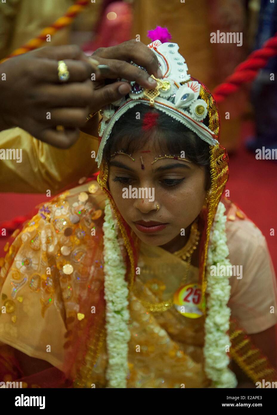 Calcutta, India. 18th June, 2014. An Indian bride attends a mass wedding in Calcutta, capital of eastern Indian state West Bengal, India, June 18, 2014. Mass weddings in India are often held by social organizations with the aim to help the couples who cannot afford the high wedding costs as well as the expensive dowry and gifts. Credit:  Tumpa Mondal/Xinhua/Alamy Live News Stock Photo