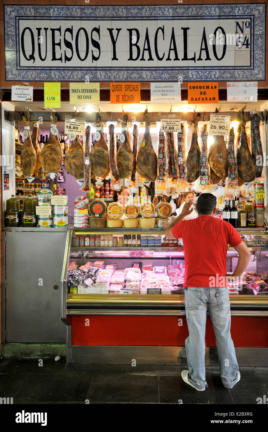Spain, Andalucia, Seville, Triana market, man standing in front of a ham and cod store Stock Photo