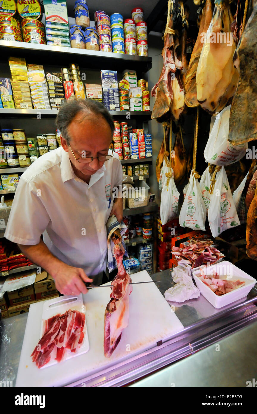 Spain, Andalucia, Seville, Triana market, man cutting ham Bellota Stock Photo