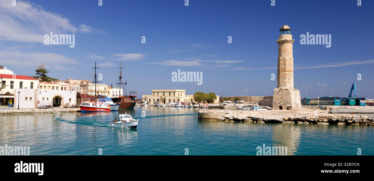Greece, Crete, Rethymnon, small white boat coming from the Venetian harbor and sailing next to the lighthouse Stock Photo