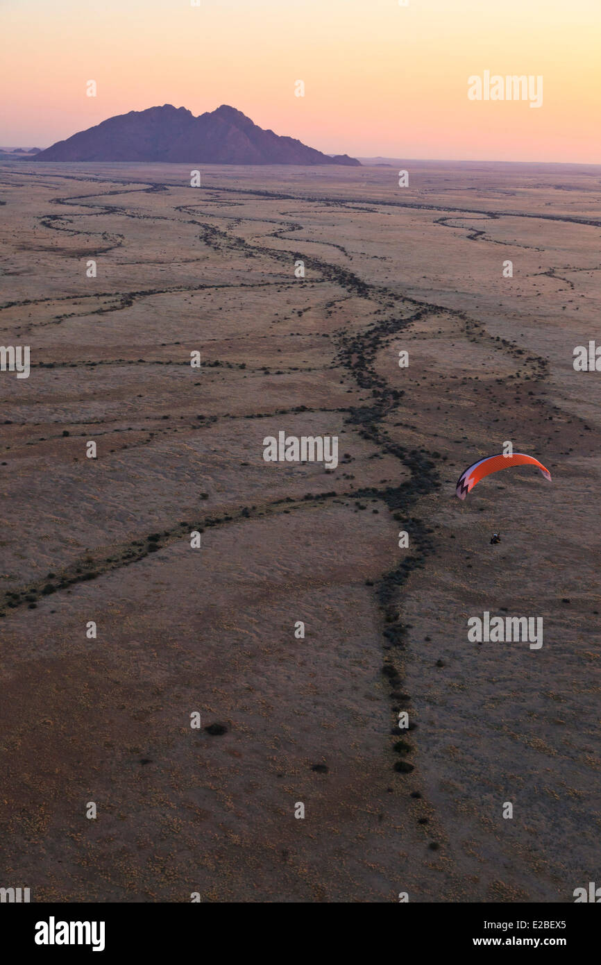 Namibia, Erongo Region, Damaraland, Spitzkoppe or Kleine Spitzkop, granite mountain in Namib Desert, paramotor (aerial view) Stock Photo