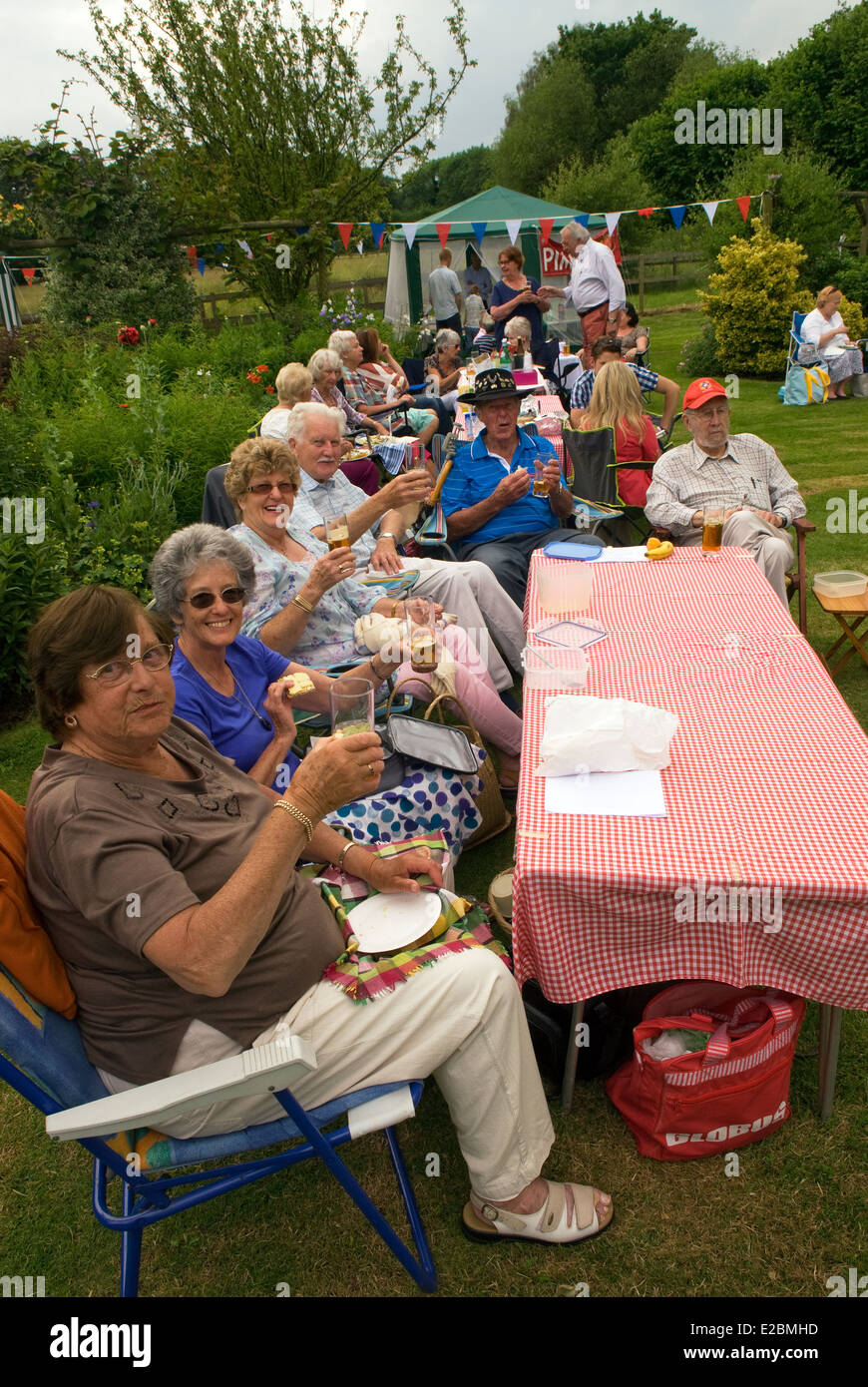 Group of elderly eople enjoying a glass of Pimms at a summer garden party, Standford, Hampshire, UK. Stock Photo