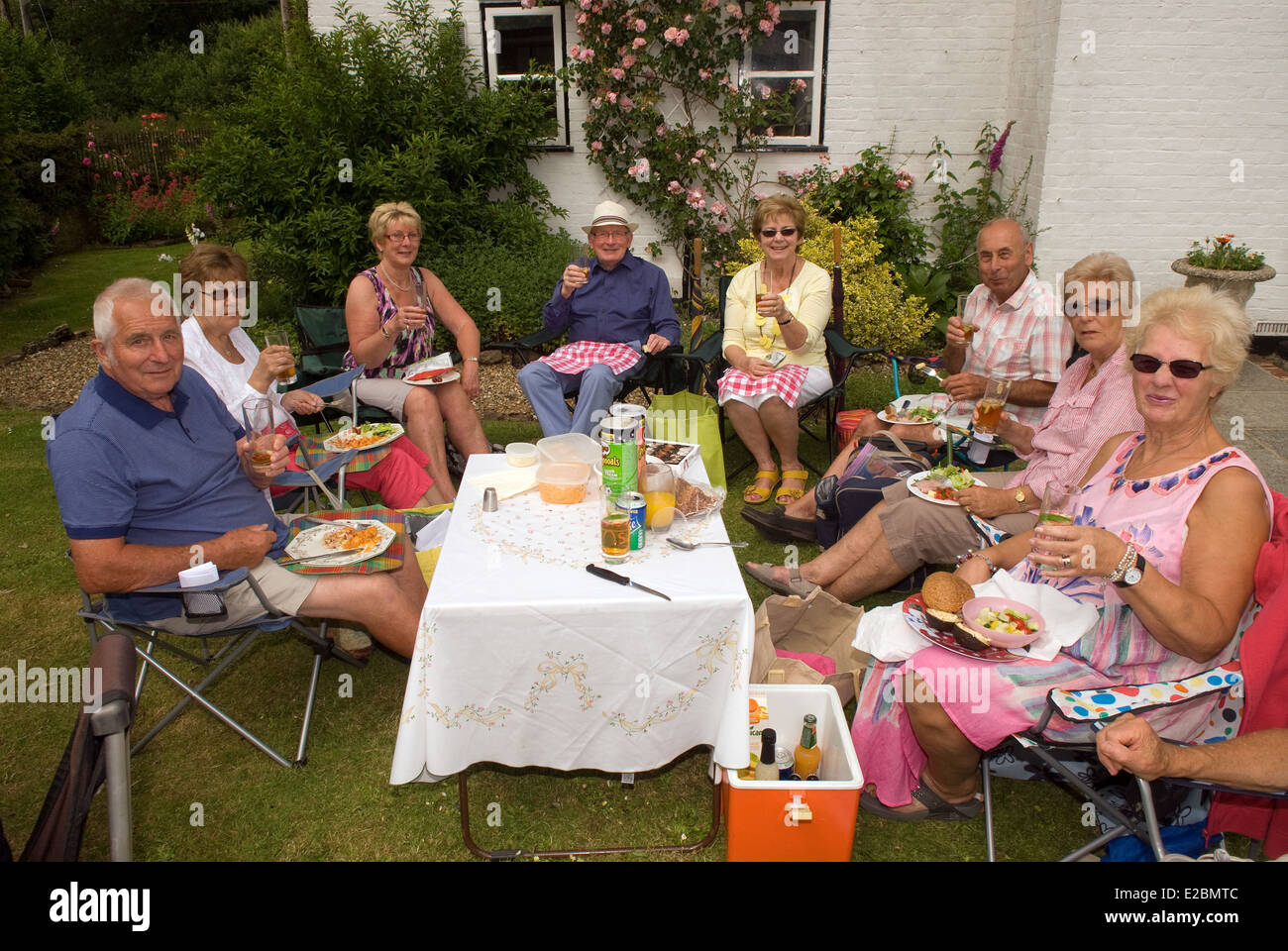 Group of people enjoying a picnic and drinks at a summer garden/Pimms party, Standford, Hampshire, UK. Stock Photo