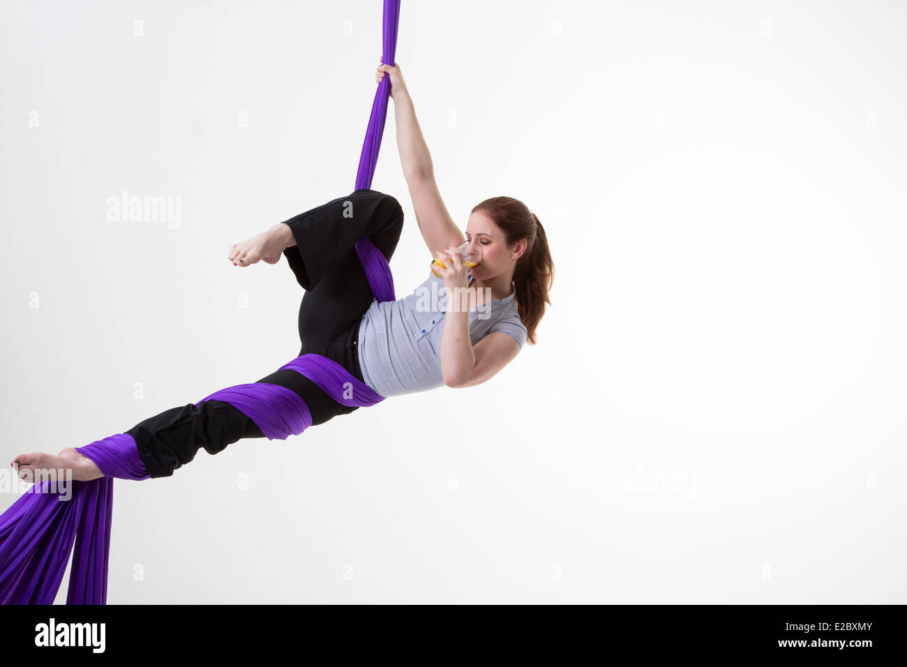 Work-life balance Woman suspended from the ceiling drinking from a mug ...